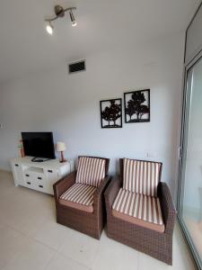 two chairs and a television in a living room at Magnifico Paradis Village in Salou
