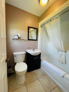 La salle de bains est pourvue de toilettes, d'un lavabo et d'une baignoire. dans l'établissement Scenic Motel Moncton, à Moncton