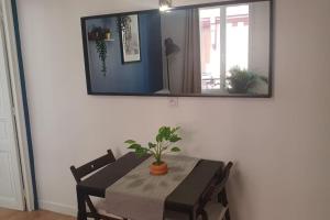 ein Esszimmer mit Tisch und Spiegel in der Unterkunft Appartement palais de justice in Rouen