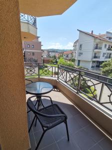 a balcony with a table and chairs and a view at Duma Apartmani Vrnjačka Banja in Vrnjci
