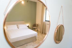 - une chambre avec un lit blanc et un miroir dans l'établissement Tenuta Concamarau, à Muro Leccese