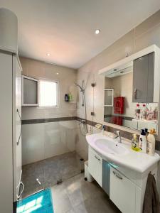 La salle de bains blanche est pourvue d'un lavabo et d'une douche. dans l'établissement Villa Elena, à Midoun