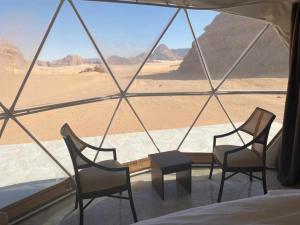 a room with chairs and a view of the desert at Rum Armony camp in Wadi Rum