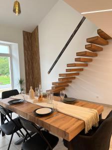 a dining room with a wooden table and a staircase at Bulles de Nature in Rizaucourt