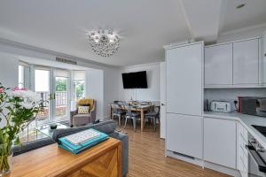 uma cozinha e sala de estar com um sofá e uma mesa em Finest Retreats - Y Lle Hapus em Tenby