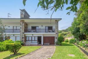 an exterior view of a house with a yard at Villa Vacacional Toró Playa in Llanes