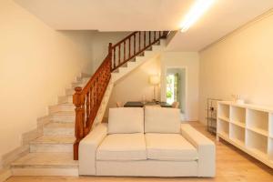 a living room with a white couch and stairs at Villa Vacacional Toró Playa in Llanes