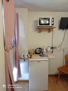 una piccola cucina con frigorifero bianco e forno a microonde di canton 520 camera matrimoniale e appartamento self check in a Livigno