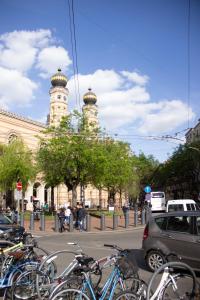 een groep fietsen geparkeerd voor een gebouw met een klokkentoren bij Luxury Downtown 3 Bedroom Apartment by Synagoge with Beautiful View in Boedapest