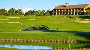 un campo de golf con un puente sobre un verde en Les Arcs en Agrate Conturbia