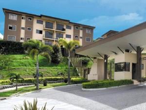 un gran edificio de apartamentos con palmeras enfrente en Namaje Tres Ros en Tres Ríos