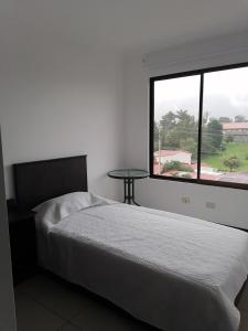 1 dormitorio con cama, ventana y mesa en Namaje Tres Ros, en Tres Ríos