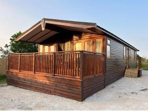 a wooden cabin with a porch and a deck at Woodpecker Lodge in Newquay