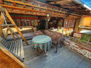 Tavern Hostel仁和客栈 في شانغريلا: طاولة وكراسي على شرفة منزل