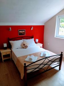 um quarto com uma cama com uma parede vermelha em Apartment Sana em Bribir