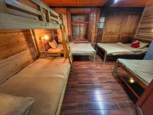 a room with three bunk beds in a cabin at Tavern Hostel仁和客栈 in Shangri-La