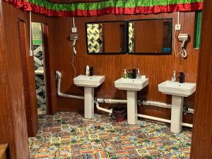 a bathroom with two sinks and a mirror at Tavern Hostel仁和客栈 in Shangri-La