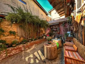 a patio with benches and potted plants on a brick wall at Tavern Hostel仁和客栈 in Shangri-La