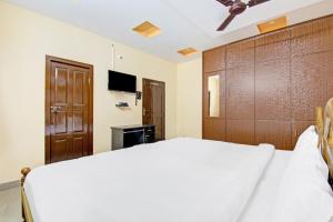 a bedroom with a white bed and a wooden headboard at Flagship Sea Coastal in Kākināda