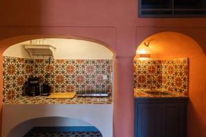 uma cozinha com um arco e um lavatório num quarto em St.Mammas Traditional Apartment em Mesaria