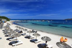 a group of chairs and umbrellas on a beach at Le Pinarello in Sainte-Lucie de Porto-Vecchio