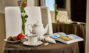 a table topped with a tea pot and a book at Albergo Diffuso Birkin Castello in Cagliari