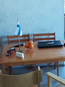 a wooden table with a laptop and a bowl of oranges at 60 neliön kaksio 300 m keskustaan in Seinäjoki