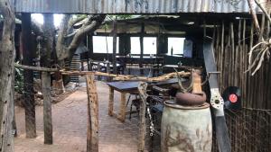 a patio with a table and an umbrella and a fence at Woodlands Cottages & Camping in Kenton +4 photos
