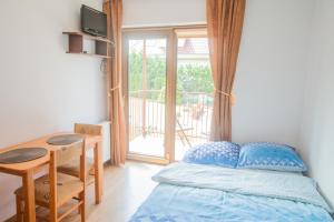 a bedroom with a bed and a table and a window at Żółta Chata in Władysławowo