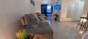 ein Wohnzimmer mit einem Sofa und einem TV in der Unterkunft Incrível localização 102, apenas 4 min do Parque in Piratuba