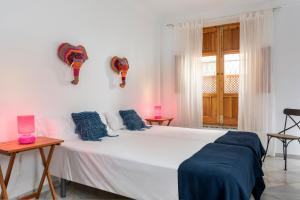 1 dormitorio con 1 cama blanca grande con almohadas azules en Lepanto Premium Apartments, en Sevilla