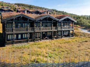 ein großes Haus auf einem Hügel mit einem Zaun in der Unterkunft Leilighet sentralt på Beitostølen in Beitostøl