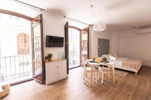 - un salon avec un lit et une table avec des chaises dans l'établissement Apartamento Especería Blue by #CuatroCallesFlats, à Malaga