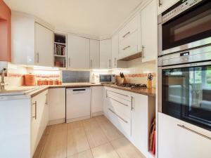 uma cozinha branca com armários e electrodomésticos brancos em Pass the Keys Close to Uni homely and suitable for families em Exeter