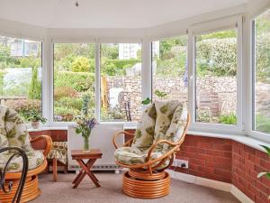 Habitación con 2 sillas frente a las ventanas en Pass the Keys Close to Uni homely and suitable for families, en Exeter