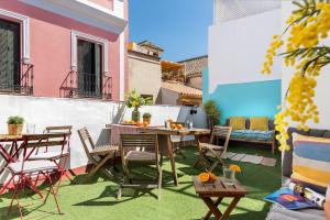 un patio con mesa y sillas en el césped en Lepanto Premium Apartments, en Sevilla