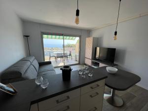 Una sala de estar con un sofá y una mesa con copas de vino. en Baie des Anges, en La Ciotat