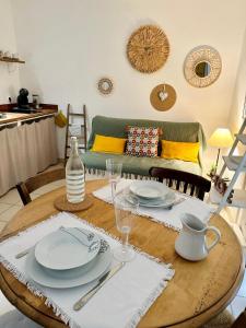 a dining room table with plates and glasses on it at la Maison Jaune in Cagnes-sur-Mer