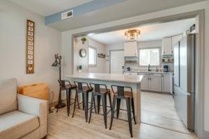 Una cocina con una barra con taburetes y un sofá. en Family-Friendly Leland Home with Patio and Grill, en Leland