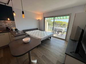 een kamer met een bed, een tafel en een keuken bij Baie des Anges in La Ciotat