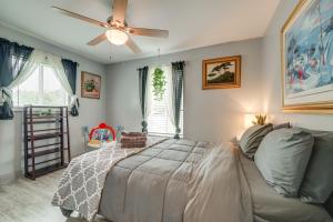 Un dormitorio con una cama y un ventilador de techo. en Family-Friendly Leland Home with Patio and Grill, en Leland