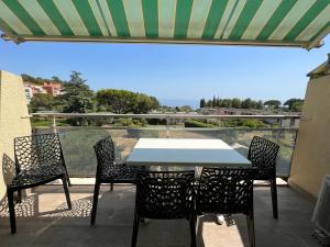 Una mesa y sillas en un patio con vista. en Baie des Anges, en La Ciotat