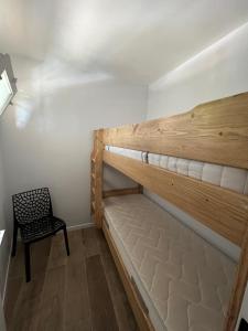 Ce lit superposé se trouve dans un dortoir doté d'une chaise. dans l'établissement Baie des Anges, à La Ciotat