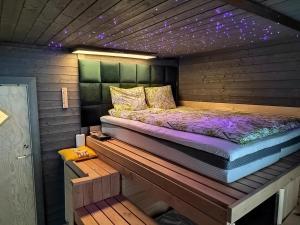 a bed in a wooden room with lights on it at Private apartment suite with sauna themed bedroom, private jacuzzi, city center by train 15min in Helsinki
