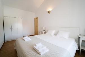1 dormitorio con 1 cama blanca y 2 toallas en Apartman Marija en Betina