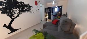 uma sala de estar com um estêncil de árvore na parede em Apenas 5 min das Àguas Termais, lindo apto 204 em Piratuba