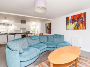 a living room with a blue couch and a table at 8 Pottergate Mews in Helmsley