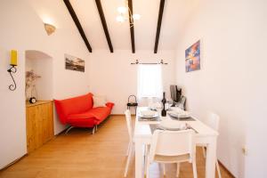 sala de estar con mesa y silla roja en Apartman Marija en Betina