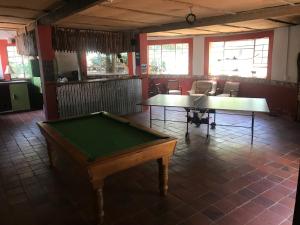 a room with two tables and a pool table at Woodlands Cottages & Camping in Kenton