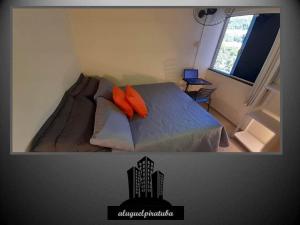 een slaapkamer met een bed met oranje kussens en een raam bij Apto climatizado 502, apenas 5 min das Thermas in Piratuba